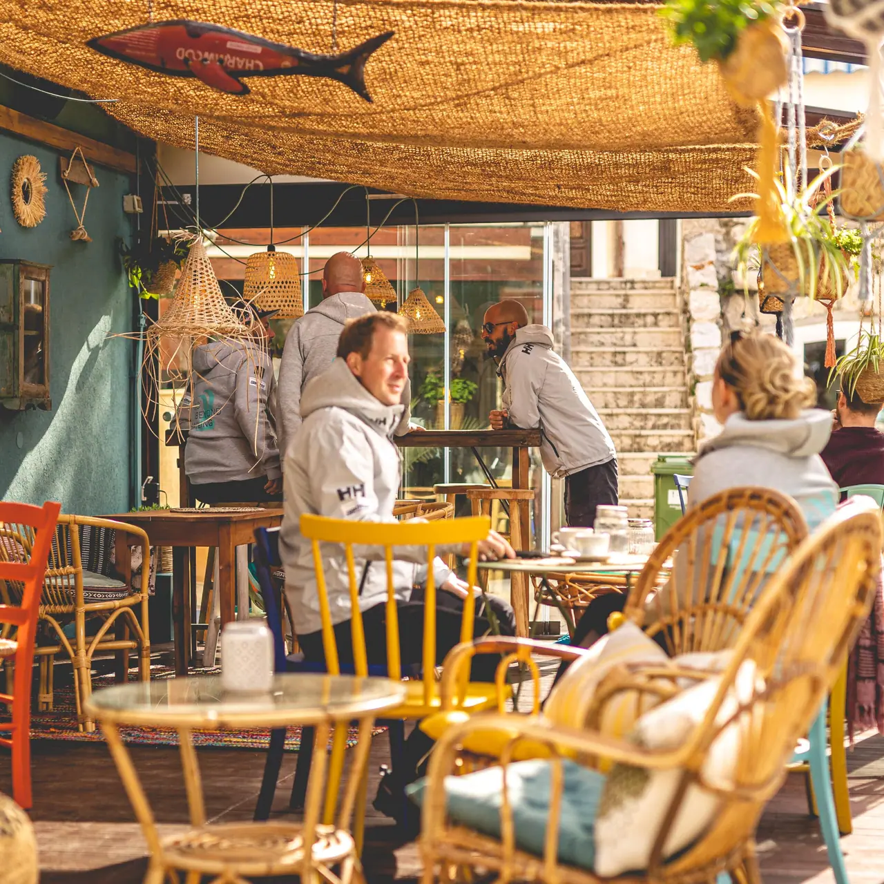 Guests in sailing jackets sitting at the terrace tables in the late afternoon
