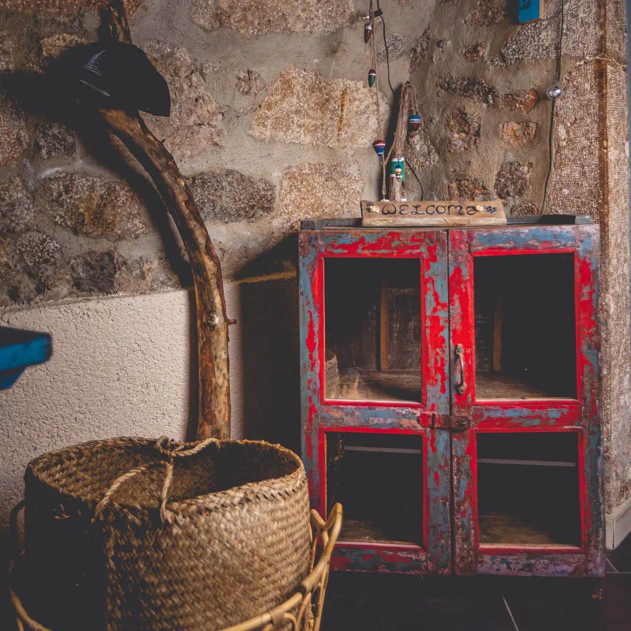 Two rope-hung wooden shelves with small potted plants against a pale wall